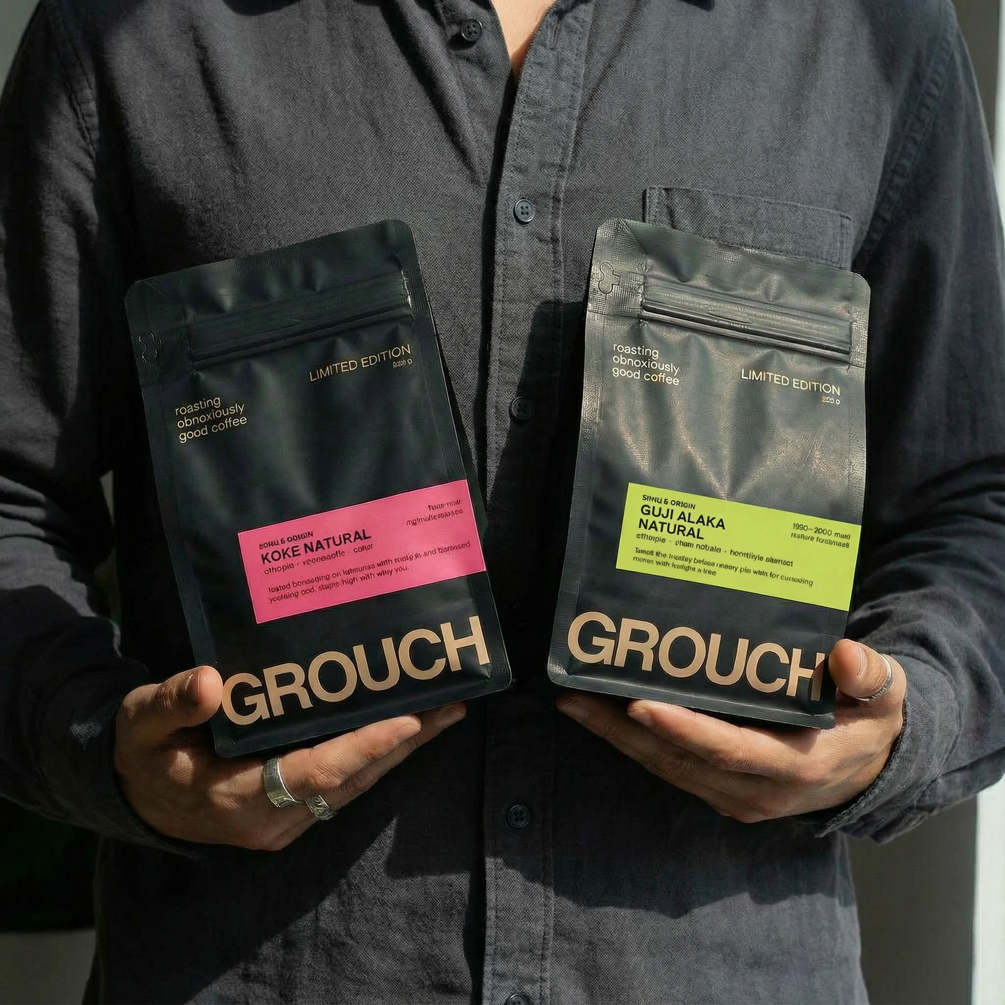 Person holding two bags of Grouch coffee